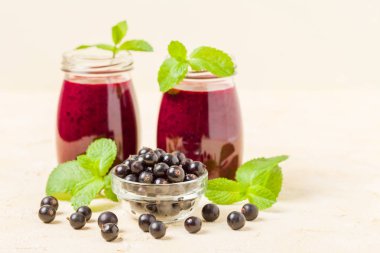 Taze yeşil nane yaprakları ve ham Olgun meyveleri yaz karışımlı vitamini sağlıklı gıda kavramı için kokteyl şeffaf kavanoz sarı pastel arka planda - frenk üzümü güler yüzlü süslenmiş.