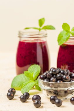 Taze yeşil nane yaprakları ve ham Olgun meyveleri yaz karışımlı vitamini sağlıklı gıda kavramı için kokteyl şeffaf kavanoz sarı pastel arka planda - frenk üzümü güler yüzlü süslenmiş.