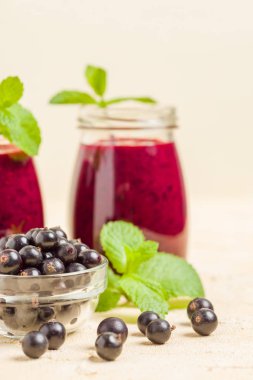 Taze yeşil nane yaprakları ve ham Olgun meyveleri yaz karışımlı vitamini sağlıklı gıda kavramı için kokteyl şeffaf kavanoz sarı pastel arka planda - frenk üzümü güler yüzlü süslenmiş.