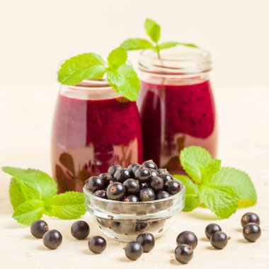 Taze yeşil nane yaprakları ve ham Olgun meyveleri yaz karışımlı vitamini sağlıklı gıda kavramı için kokteyl şeffaf kavanoz sarı pastel arka planda - frenk üzümü güler yüzlü süslenmiş.