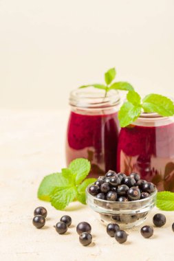 Taze yeşil nane yaprakları ve ham Olgun meyveleri yaz karışımlı vitamini sağlıklı gıda kavramı için kokteyl şeffaf kavanoz sarı pastel arka planda - frenk üzümü güler yüzlü süslenmiş.