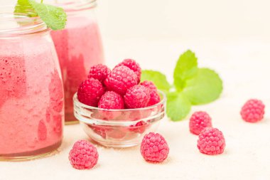 Ahududu güler yüzlü yakın taze yaz fotoğrafla kadar kokteyl ve olgun çilek sağlıklı beslenme ve yaşam tarzı konsepti için pastel sarı zemin üzerine karışık.