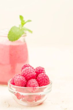 Ahududu güler yüzlü yakın taze yaz fotoğrafla kadar kokteyl ve olgun çilek sağlıklı beslenme ve yaşam tarzı konsepti için pastel sarı zemin üzerine karışık.