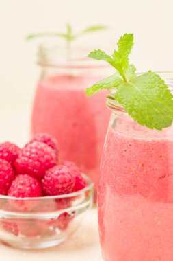 Ahududu güler yüzlü yakın taze yaz fotoğrafla kadar kokteyl ve olgun çilek sağlıklı beslenme ve yaşam tarzı konsepti için pastel sarı zemin üzerine karışık.