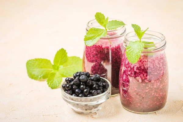 Taze yeşil nane yaprakları ve ham Olgun meyveleri yaz karışımlı vitamini kopya alanı ile kokteyl şeffaf kavanoz sarı pastel arka planda - Blueberry smoothie süslenmiş.
