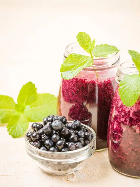 Taze yeşil nane yaprakları ve ham Olgun meyveleri yaz karışımlı vitamini kopya alanı ile kokteyl şeffaf kavanoz sarı pastel arka planda - Blueberry smoothie süslenmiş.