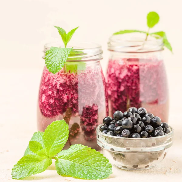 Taze yeşil nane yaprakları ve ham Olgun meyveleri yaz karışımlı vitamini kopya alanı ile kokteyl şeffaf kavanoz sarı pastel arka planda - Blueberry smoothie süslenmiş.