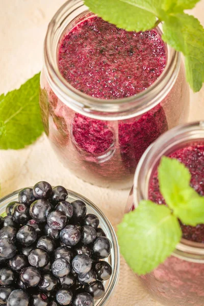 Taze yeşil nane yaprakları ve ham Olgun meyveleri yaz karışımlı vitamini kopya alanı ile kokteyl şeffaf kavanoz sarı pastel arka planda - Blueberry smoothie süslenmiş.