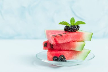 Pasta böğürtlen ve nane yaprağı ile kopya alanı - pastel mavi zemin üzerine dilimlenmiş karpuz yakın çekim yaz taze çiğ olgunlaşmış meyve lezzetli vejetaryen tatlı makro fotoğrafçılık.