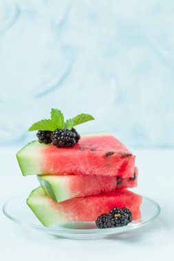 Pasta böğürtlen ve nane yaprağı ile kopya alanı - pastel mavi zemin üzerine dilimlenmiş karpuz yakın çekim yaz taze çiğ olgunlaşmış meyve lezzetli vejetaryen tatlı makro fotoğrafçılık.