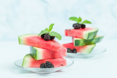 Pasta böğürtlen ve nane yaprağı ile kopya alanı - pastel mavi zemin üzerine dilimlenmiş karpuz yakın çekim yaz taze çiğ olgunlaşmış meyve lezzetli vejetaryen tatlı makro fotoğrafçılık.