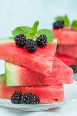 Böğürtlen ve nane yaprağı ile pasta üzerinde mavi pastel renkli - dilimlenmiş karpuz yakın çekim yaz taze çiğ olgunlaşmış meyve lezzetli vejetaryen tatlı makro fotoğrafçılık.