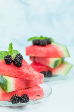 Pasta böğürtlen ve nane yaprağı ile kopya alanı - pastel mavi zemin üzerine dilimlenmiş karpuz yakın çekim yaz taze çiğ olgunlaşmış meyve lezzetli vejetaryen tatlı makro fotoğrafçılık.