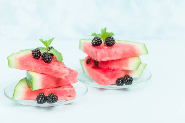 Böğürtlen ve nane yaprağı ile pasta üzerinde mavi pastel renkli - dilimlenmiş karpuz yakın çekim yaz taze çiğ olgunlaşmış meyve lezzetli vejetaryen tatlı makro fotoğrafçılık.