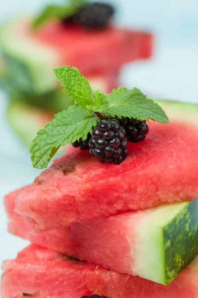 Böğürtlen ve nane yaprağı ile pasta üzerinde mavi pastel renkli - dilimlenmiş karpuz yakın çekim yaz taze çiğ olgunlaşmış meyve lezzetli vejetaryen tatlı makro fotoğrafçılık.