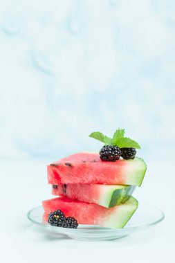 Pasta böğürtlen ve nane yaprağı ile kopya alanı - pastel mavi zemin üzerine dilimlenmiş karpuz yakın çekim yaz taze çiğ olgunlaşmış meyve lezzetli vejetaryen tatlı makro fotoğrafçılık.