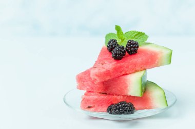 Pasta böğürtlen ve nane yaprağı ile kopya alanı - pastel mavi zemin üzerine dilimlenmiş karpuz yakın çekim yaz taze çiğ olgunlaşmış meyve lezzetli vejetaryen tatlı makro fotoğrafçılık.