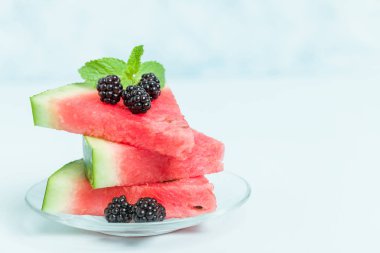 Pasta böğürtlen ve nane yaprağı ile kopya alanı - pastel mavi zemin üzerine dilimlenmiş karpuz yakın çekim yaz taze çiğ olgunlaşmış meyve lezzetli vejetaryen tatlı makro fotoğrafçılık.