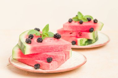 Karpuz dilim pasta böğürtlen ve pastel sarı arka plan - nane yaprağı ile yakın çekim yaz taze çiğ olgunlaşmış meyve lezzetli vejetaryen tatlı makro fotoğrafçılık.