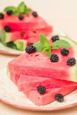 Karpuz dilim pasta böğürtlen ve pastel sarı arka plan - nane yaprağı ile yakın çekim yaz taze çiğ olgunlaşmış meyve lezzetli vejetaryen tatlı makro fotoğrafçılık.