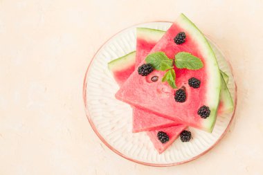 Karpuz dilim pasta böğürtlen ve kopya alanı - pastel sarı zemin üzerine nane yaprağı ile yakın çekim yaz taze çiğ olgunlaşmış meyve lezzetli vejetaryen tatlı makro fotoğrafçılık.
