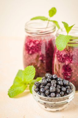 Taze yeşil nane yaprakları ve ham Olgun meyveleri yaz karışımlı vitamini kopya alanı ile kokteyl şeffaf kavanoz sarı pastel arka planda - Blueberry smoothie süslenmiş.