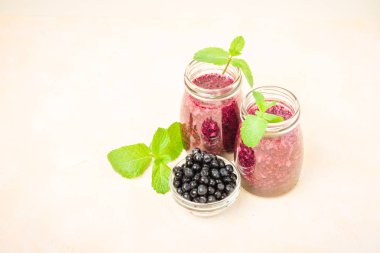 Taze yeşil nane yaprakları ve ham Olgun meyveleri yaz karışımlı vitamini kopya alanı ile kokteyl şeffaf kavanoz sarı pastel arka planda - Blueberry smoothie süslenmiş.