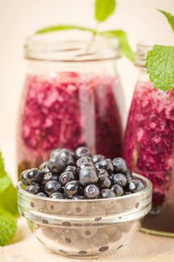 Taze yeşil nane yaprakları ve ham Olgun meyveleri yaz karışımlı vitamini kopya alanı ile kokteyl şeffaf kavanoz sarı pastel arka planda - Blueberry smoothie süslenmiş.