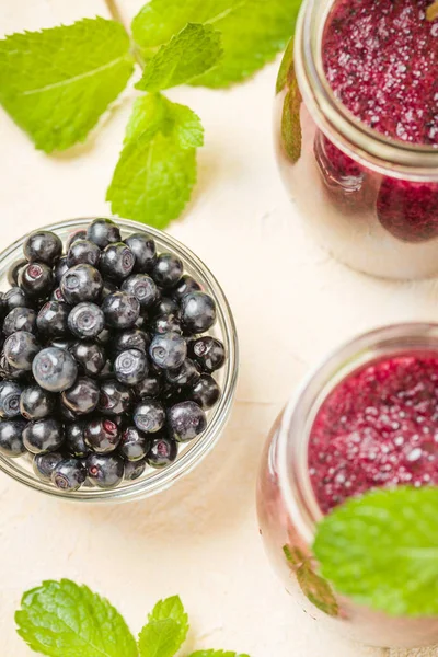Taze yeşil nane yaprakları ve ham Olgun meyveleri yaz karışımlı vitamini kopya alanı ile kokteyl şeffaf kavanoz sarı pastel arka planda - Blueberry smoothie süslenmiş.