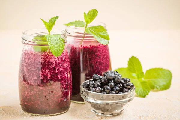 Taze yeşil nane yaprakları ve ham Olgun meyveleri yaz karışımlı vitamini kopya alanı ile kokteyl şeffaf kavanoz sarı pastel arka planda - Blueberry smoothie süslenmiş.