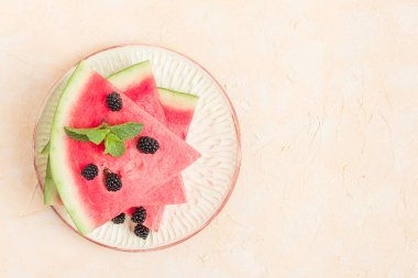 Makro fotoğrafçılık yaz taze çiğ olgunlaşmış meyve lezzetli vejetaryen tatlıya kadar yakın karpuz dilim pasta böğürtlen ve kopya alanı - pastel sarı zemin üzerine nane yaprağı ile üstten görünüm.