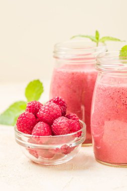 Ahududu güler yüzlü yakın taze yaz fotoğrafla kadar kokteyl ve olgun çilek sağlıklı beslenme ve yaşam tarzı konsepti için pastel sarı zemin üzerine karışık.