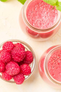 Ahududu güler yüzlü yakın taze yaz fotoğrafla kadar kokteyl ve olgun çilek sağlıklı beslenme ve yaşam tarzı konsepti için pastel sarı zemin üzerine karışık.