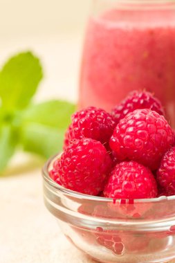 Ahududu güler yüzlü yakın taze yaz fotoğrafla kadar kokteyl ve olgun çilek sağlıklı beslenme ve yaşam tarzı konsepti için pastel sarı zemin üzerine karışık.