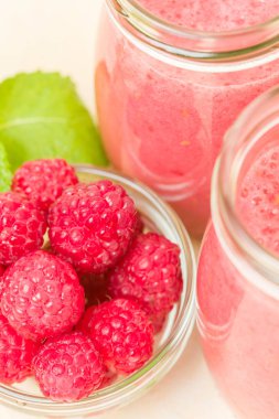 Ahududu güler yüzlü yakın taze yaz fotoğrafla kadar kokteyl ve olgun çilek sağlıklı beslenme ve yaşam tarzı konsepti için pastel sarı zemin üzerine karışık.