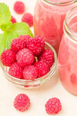 Ahududu güler yüzlü yakın taze yaz fotoğrafla kadar kokteyl ve olgun çilek sağlıklı beslenme ve yaşam tarzı konsepti için pastel sarı zemin üzerine karışık.