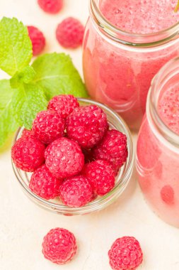 Ahududu güler yüzlü yakın taze yaz fotoğrafla kadar kokteyl ve olgun çilek sağlıklı beslenme ve yaşam tarzı konsepti için pastel sarı zemin üzerine karışık.