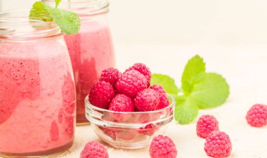 Ahududu güler yüzlü yakın taze yaz fotoğrafla kadar kokteyl ve olgun çilek sağlıklı beslenme ve yaşam tarzı konsepti için pastel sarı zemin üzerine karışık.