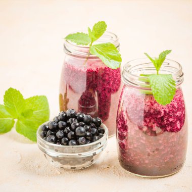 Taze yeşil nane yaprakları ve ham Olgun meyveleri yaz karışımlı vitamini kopya alanı ile kokteyl şeffaf kavanoz sarı pastel arka planda - Blueberry smoothie süslenmiş.