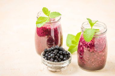 Taze yeşil nane yaprakları ve ham Olgun meyveleri yaz karışımlı vitamini kopya alanı ile kokteyl şeffaf kavanoz sarı pastel arka planda - Blueberry smoothie süslenmiş.