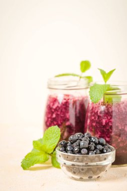 Taze yeşil nane yaprakları ve ham Olgun meyveleri yaz karışımlı vitamini kopya alanı ile kokteyl şeffaf kavanoz sarı pastel arka planda - Blueberry smoothie süslenmiş.