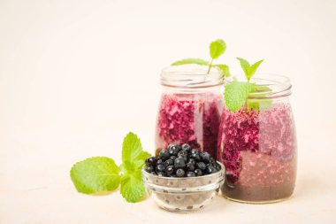 Taze yeşil nane yaprakları ve ham Olgun meyveleri yaz karışımlı vitamini kopya alanı ile kokteyl şeffaf kavanoz sarı pastel arka planda - Blueberry smoothie süslenmiş.