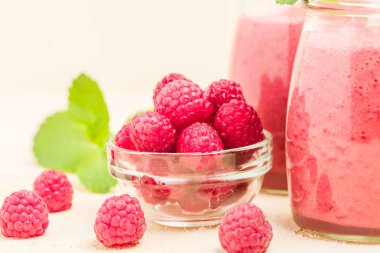 Ahududu güler yüzlü yakın taze yaz fotoğrafla kadar kokteyl ve olgun çilek sağlıklı beslenme ve yaşam tarzı konsepti için pastel sarı zemin üzerine karışık.