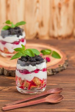 Önemsememek yakın taze multi fotoğrafla kadar tatlı süt ve olgun ahududu ve böğürtlen ahşap arka plan - meyve organik sağlıklı yemekle tatlı üzerinde katmanlı.