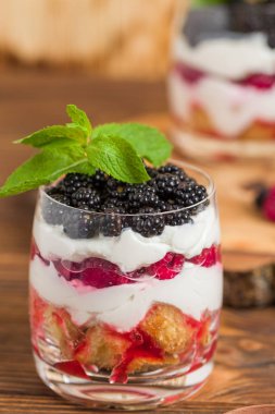 Önemsememek yakın taze multi fotoğrafla kadar tatlı süt ve olgun ahududu ve böğürtlen ahşap arka plan - meyve organik sağlıklı yemekle tatlı üzerinde katmanlı.