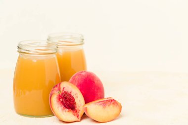 Sarı pastel arka plan - ham tatlı turuncu tatlı veya kahvaltı içki sağlıklı organik beslenme kavramı üzerinde taze olgunlaşmış meyve ile cam kavanozlara şeftali yüzlü.