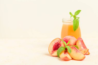 Taze olgunlaşmış meyve ve yeşil nane yaprakları sarı pastel arka plan - ham şekerli tatlı veya kahvaltı içki sağlıklı organik beslenme kavramı üzerinde cam kavanozlara şeftali yüzlü.