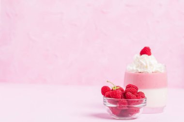 Ahududu panna cotta pastel pembe - krem ve olgun berry ile dekore edilmiş kapatmak kadar tatlı süt tatlı yaz meyve güzel gözlük ile fotoğraf.