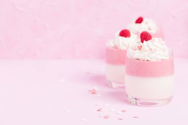 Ahududu panna cotta üzerinde pastel pembe - krem ve kalp süslemeleri ile dekore edilmiş kapatmak kadar tatlı süt tatlı yaz meyve güzel gözlük ile fotoğraf.