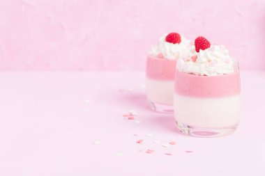 Ahududu panna cotta üzerinde pastel pembe - krem ve kalp süslemeleri ile dekore edilmiş kapatmak kadar tatlı süt tatlı yaz meyve güzel gözlük ile fotoğraf.